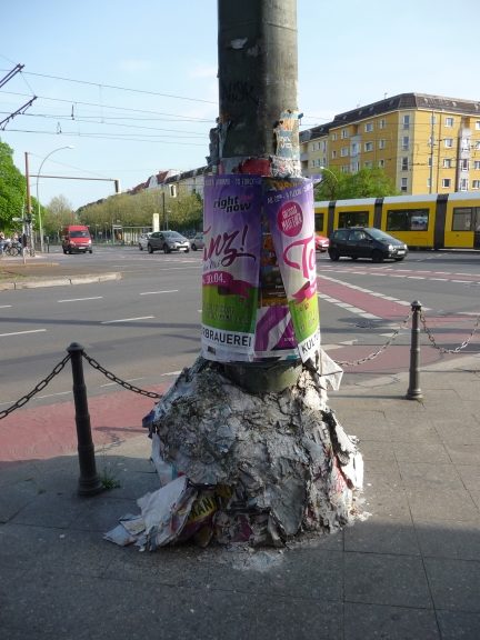 Laternenpfahl in Berlin, der vollkommen mit Plakaten ummantelt ist